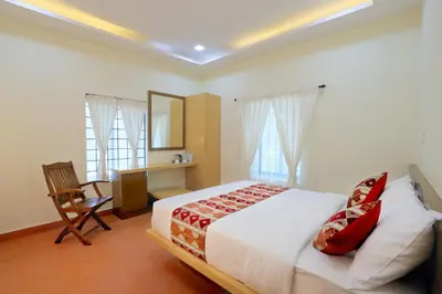 a bedroom with a bed and a desk and windows at Ottway Hills Mattupetty Dam in Munnar