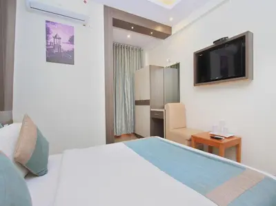 a hotel room with a bed and a flat screen tv at Aishwarya Le Royal in Mysore
