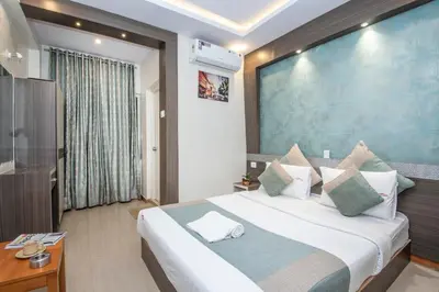 a hotel room with a large bed and a television at Aishwarya Le Royal in Mysore