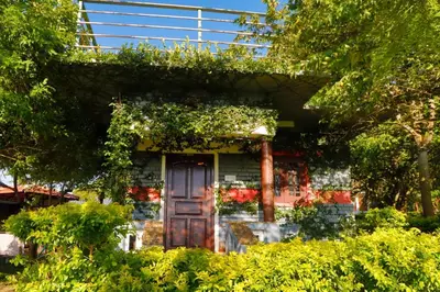 a house with a door and ivy on it at Chalets Resort Masinagudi in Ooty