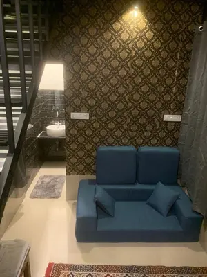 a blue couch in a room with a sink at Chalets Resort Masinagudi in Ooty