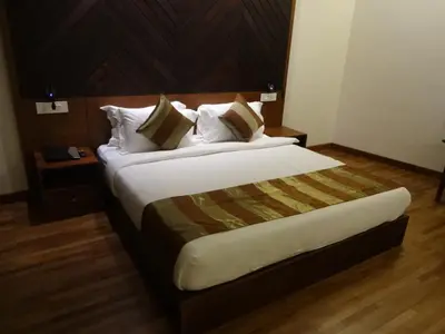 a bedroom with a large bed with a wooden headboard at Woodies Bleisure Hotel in Kozhikode