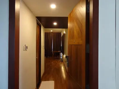 a hallway with wooden floors and a room with a door at Woodies Bleisure Hotel in Kozhikode