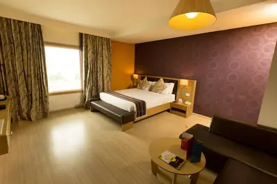 a hotel room with a bed and a couch at M Inn in Coimbatore