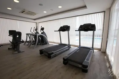 a gym with treadmills and elliptical machines at M Inn in Coimbatore