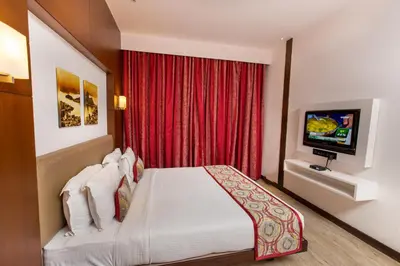 a hotel room with a bed and a television at M Inn in Coimbatore