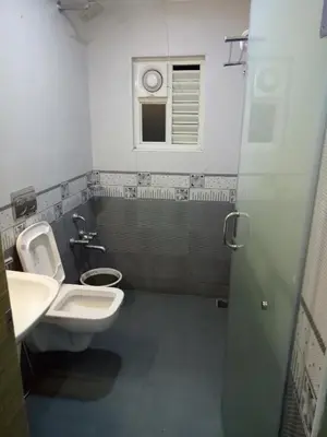 a bathroom with a sink and a toilet and a window at Suroor Tourist Home in Virajpet
