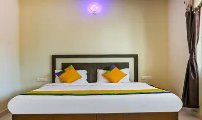 a bedroom with a bed with colorful pillows at Itsy Hotels Kottaram Residency, 10 Mins To Botanical Garden in Ooty