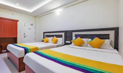 a bedroom with two beds with colorful pillows at Itsy Hotels Kottaram Residency, 10 Mins To Botanical Garden in Ooty