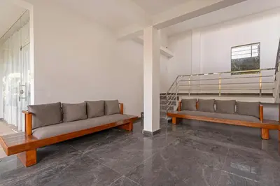 two couches in a room with a staircase at Itsy Hotels Jammabane Cottage, 5 Minutes To Mountain View Coffee Plantation in Madikeri