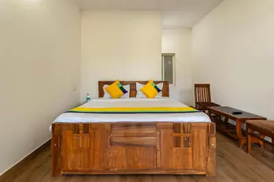a bedroom with a large wooden bed with yellow pillows at Itsy Hotels Jammabane Cottage, 5 Minutes To Mountain View Coffee Plantation in Madikeri