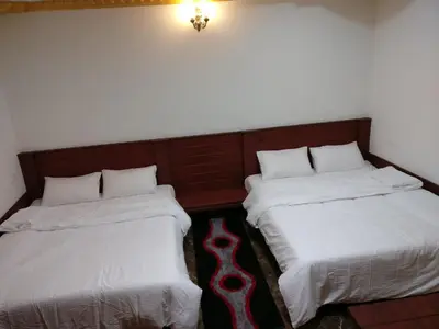 two beds sitting next to each other in a room at The Shades Holiday Homes in Kushālnagar