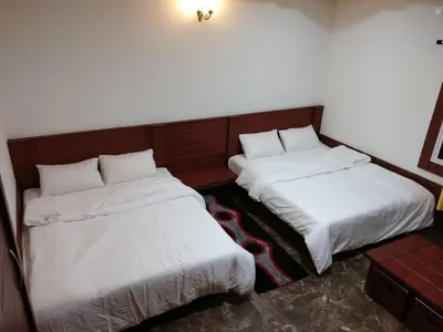 two beds sitting next to each other in a room at The Shades Holiday Homes in Kushālnagar