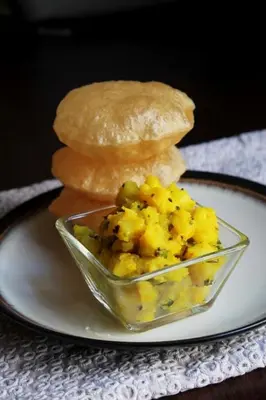 a plate with a sandwich and a bowl of scrambled eggs at The Shades Holiday Homes in Kushālnagar