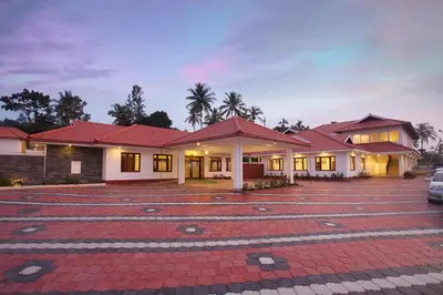 a house with a parking lot in front of it at Le Coffee Resort in Sultan Bathery