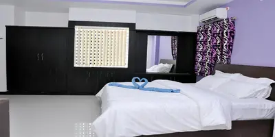 a white bed with a blue ribbon on top of it at Sara Regency in Palani