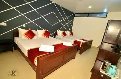 a bedroom with two beds with red pillows at Royal Serene Villas in Ooty