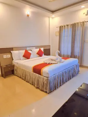 a bedroom with a bed with a swan on it at Alfa Inn in Nedumbassery