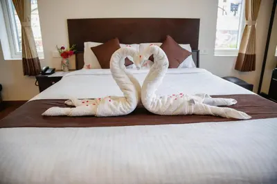 two swansrendered to look like they are kissing on a bed at Paradise Perfect - Nonsmoking Non alcoholic No unmarried couples in Ooty