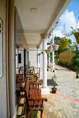 a row of benches on a patio with potted plants at Paradise Perfect - Nonsmoking Non alcoholic No unmarried couples in Ooty