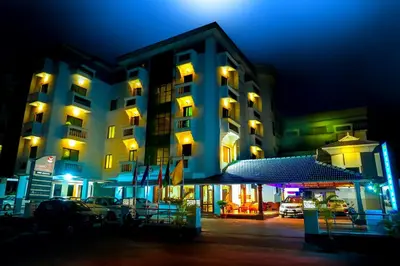 a large building with cars parked outside of it at night at Hotel Horizon International in Guruvāyūr