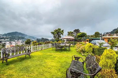 a group of benches sitting in the grass at Via St Clouds - Nr Government Botanical Garden in Ooty