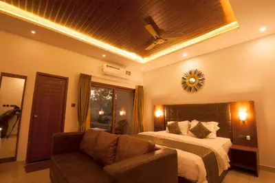 a hotel room with a bed and a couch at MC Resort Wildlife Resort Bandipur in Bandipūr