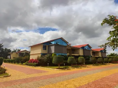 a row of houses on a street with bushes at Bandipur Wildlife Resort & Spa, Bandipur in Bandipūr