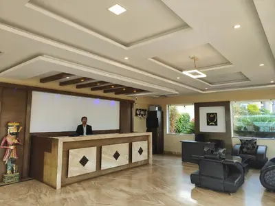 a man is standing behind a podium in a lobby at Bandipur Wildlife Resort & Spa, Bandipur in Bandipūr