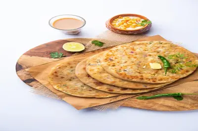 two pita breads on a wooden cutting board with sauce at FabHotel Thejas Paaradise - Nr Coimbatore Institute of Technology in Coimbatore