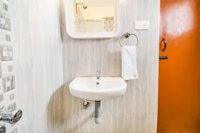 a bathroom with a white sink and a mirror at FabHotel Thejas Paaradise - Nr Coimbatore Institute of Technology in Coimbatore