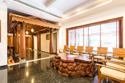 a room with a table and chairs and a large window at Sterling Guruvayur in Guruvāyūr