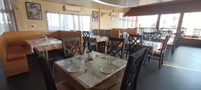 a dining room with tables and chairs in a restaurant at The Cocoon in Gonikoppal