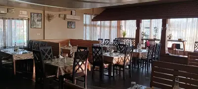 a restaurant with tables and chairs in a room at The Cocoon in Gonikoppal