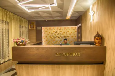 a reception desk in a hotel with a man behind it at The Cocoon in Gonikoppal