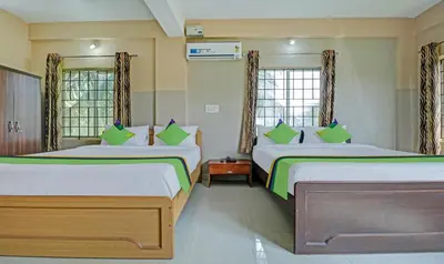 a bedroom with two beds and two windows at Treebo Green Land Coorg in Kushālnagar