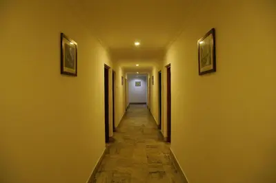 an empty hallway with yellow walls and a long corridor at Kairali Tourist Home in Guruvāyūr