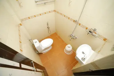 a small bathroom with a toilet and a sink at Kairali Tourist Home in Guruvāyūr
