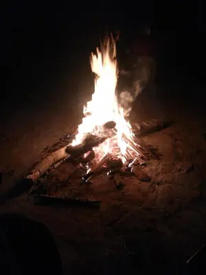 a large bonfire is lit up in the dark at Wayanad Royal Stream in Kalpetta