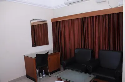a room with two chairs and a desk and curtains at Alhind Calicut Tower in Kozhikode