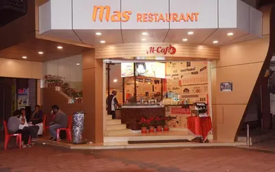 a mas restaurant with people sitting in front of it at Alhind Calicut Tower in Kozhikode