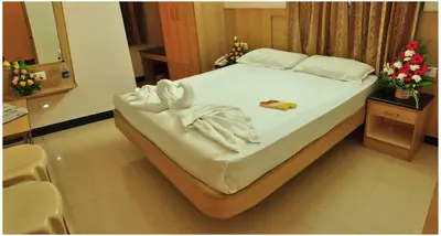a bedroom with a bed with towels on it at SK Residency in Coimbatore