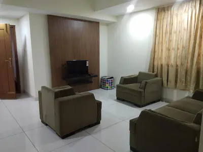 a waiting room with two chairs and a tv at Suvarna Compact in Mysore