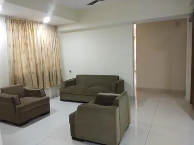a living room with couches and chairs in a room at Suvarna Compact in Mysore
