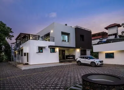 a white car parked in front of a house at Nadhiyoram River Retreat in Cochin