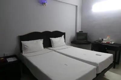 a bedroom with a large bed and a television at Hotel Span in Kozhikode
