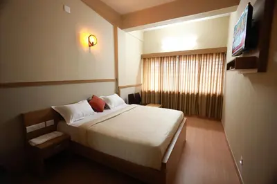 a hotel room with a bed and a television at Haksons Residency in Mananthavady
