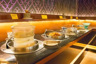 a buffet line with food in a restaurant at President Hotel in Mysore