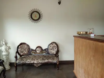 a room with a chair and a mirror on the wall at Berry Hills Resort in Ooty