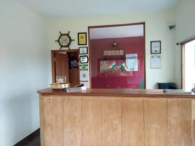 a counter in a room with a clock on the wall at Berry Hills Resort in Ooty
